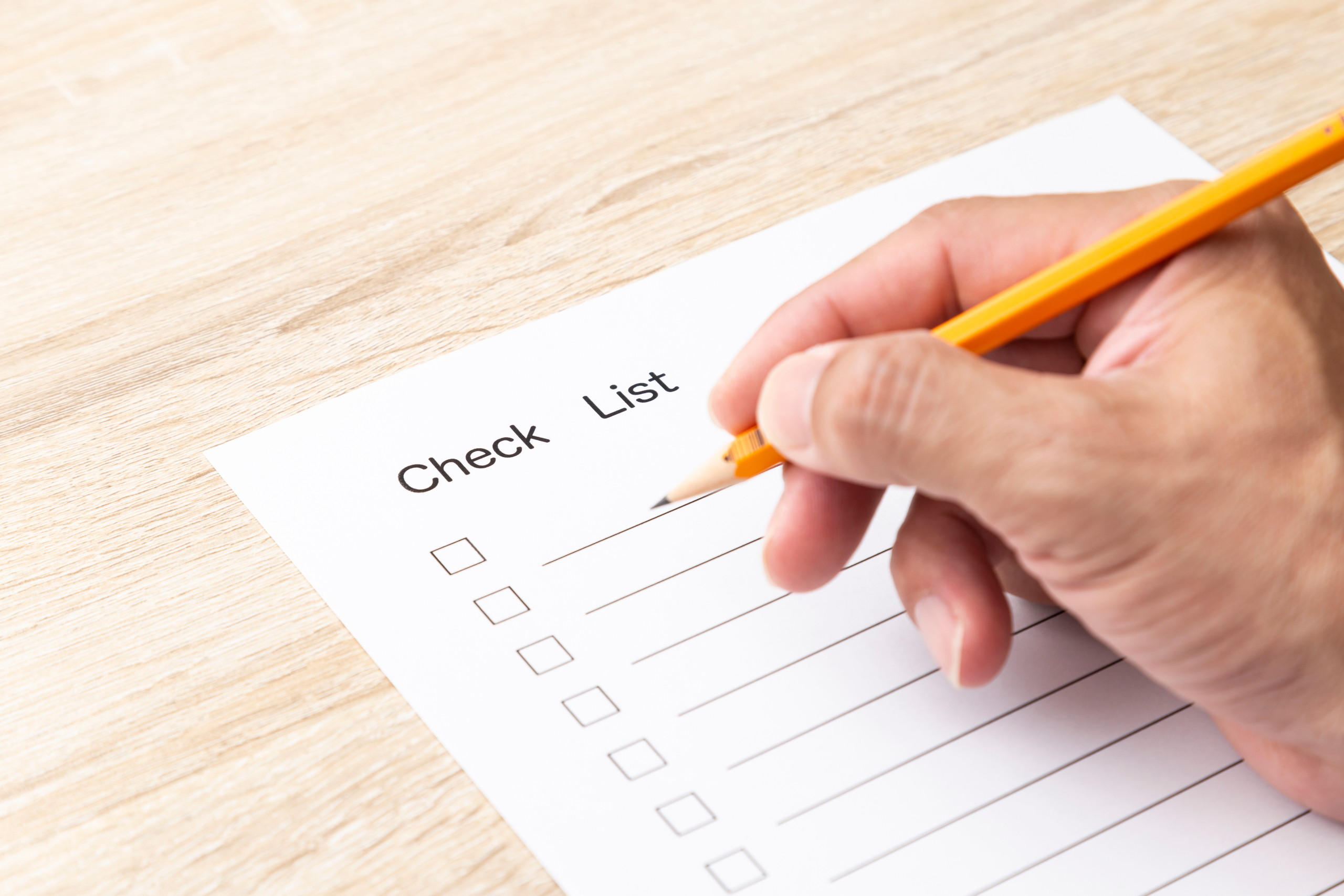 チェックリストに記入する手元