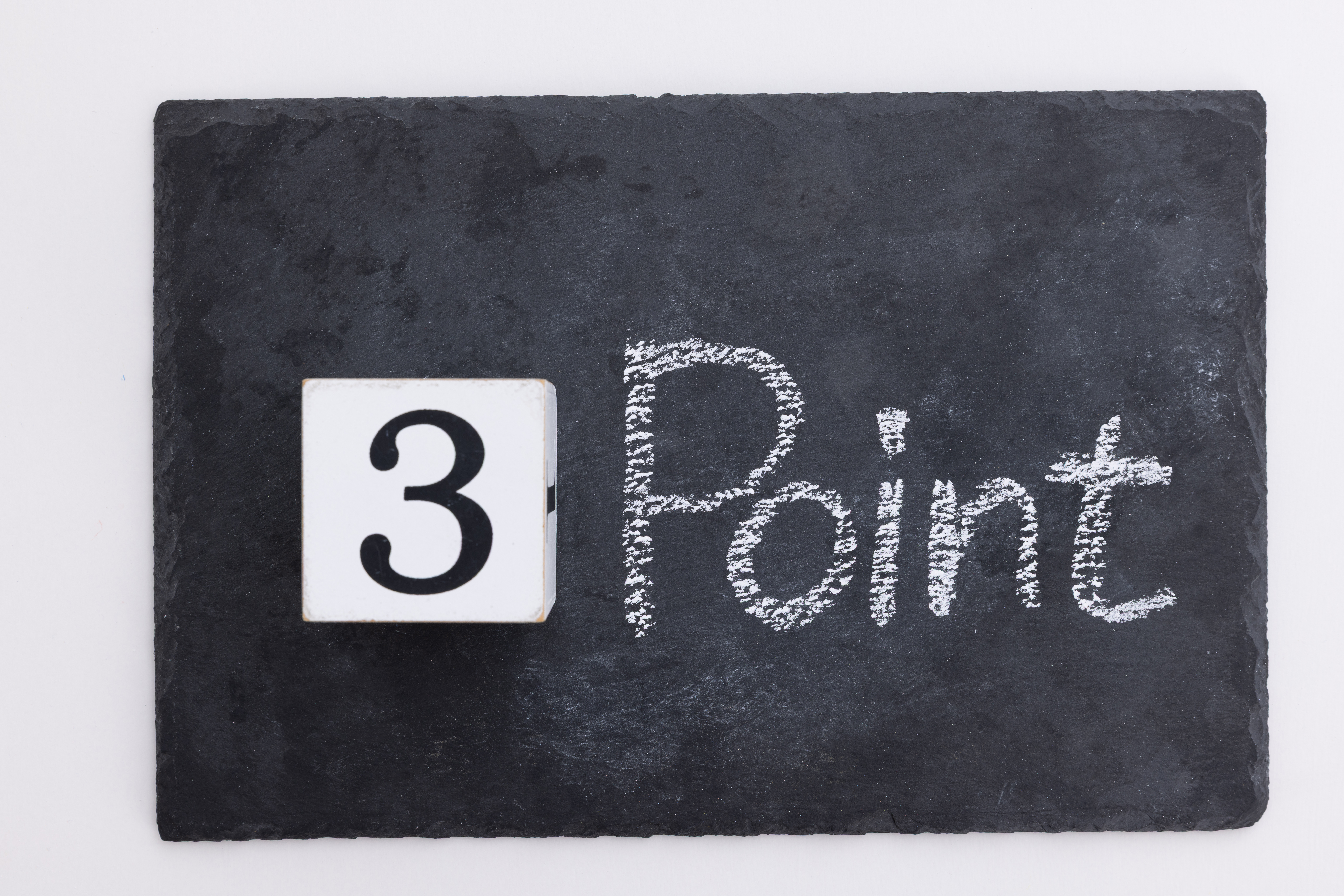 黒いスレートプレートの上に置かれた「3」の数字ブロックと、チョークで手書きされた「Point」の文字